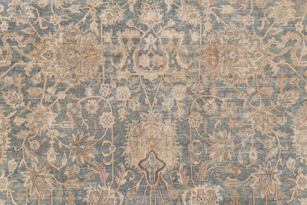 An intricate, blue and beige, Persian-style rug with a floral and vine pattern. The detailed design includes symmetrical motifs and ornate decorations, creating a classic, vintage appearance. The muted colors give this KERMAN RUG, SOUTH EAST PERSIA, 10' 8" X 14' 8" by Ben Soleimani an antique look reminiscent of museum-quality rugs.