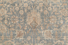 An intricate, vintage-inspired rug design features a symmetrical pattern with floral and geometric motifs. The Ben Soleimani KERMAN RUG, SOUTH EAST PERSIA, 10' 8" X 14' 8" has a distressed, weathered appearance with muted tones of blue, beige, and tan, giving it the timeless character of museum-quality rugs.