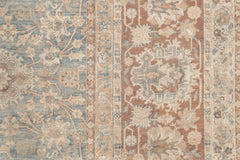 A close-up image of a vintage, intricately patterned heirloom KERMAN RUG, SOUTH EAST PERSIA, 10' 8" X 14' 8". The rug by Ben Soleimani features a combination of light blue and beige tones with detailed floral and geometric designs. The pattern includes various floral motifs and ornate shapes arranged in vertical strips, showcasing its museum-quality craftsmanship.