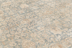 A close-up view of an intricately patterned, antique rug with a blend of light blue, beige, and cream colors. The design features floral motifs and ornate detailing that covers the entire surface, creating a delicate and elegant look reminiscent of museum-quality heirloom rugs: KERMAN RUG, SOUTH EAST PERSIA, 10' 8" X 14' 8" by Ben Soleimani.