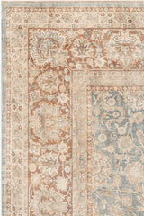 A detailed, ornate Ben Soleimani KERMAN RUG, SOUTH EAST PERSIA, 10' 8" X 14' 8" with a floral and vine pattern in muted tones of beige, rust, and pale blue. The border features intricate designs of flowers and leaves, creating a vintage and elegant appearance. This museum-quality rug's central area has a similar, slightly more subtle pattern.