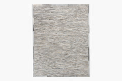 A Ladro Hide – Grey with a textured pattern in various shades of gray, featuring thin horizontal lines that give it a stone-like appearance. Part of the Ben Soleimani collection, this premium hair-on cowhide rug has a bordered design with a slightly darker gray trim around the edges.